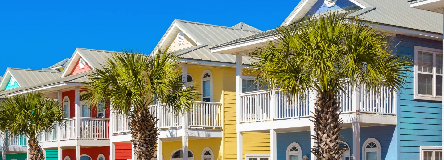 Colorful row of beach houses with palm tress for vacation co-ownership
