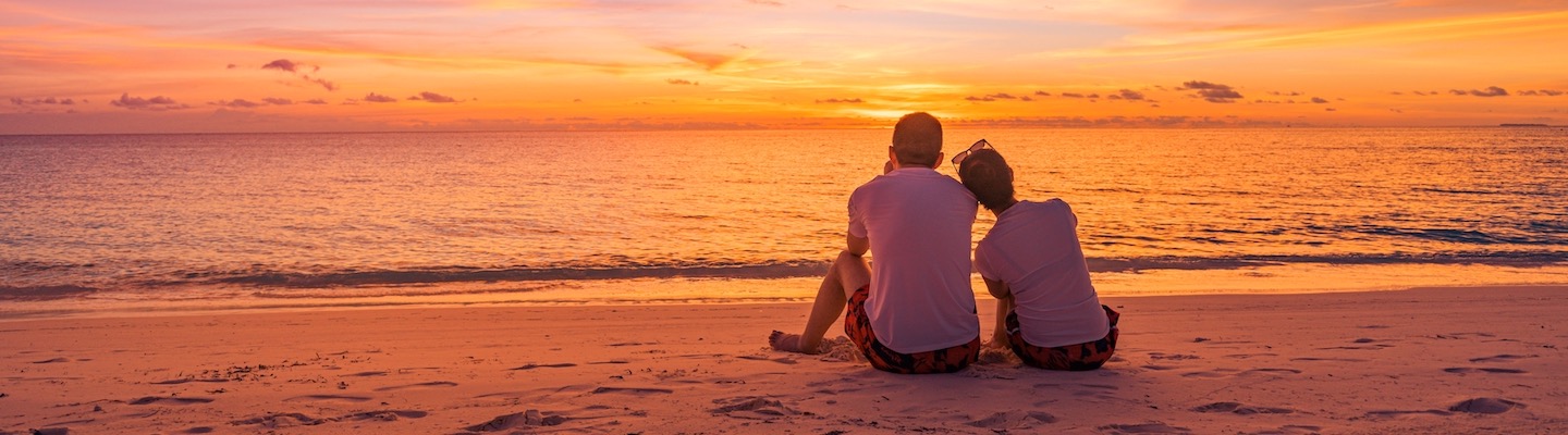 Couple watching sunset on beach at a timeshare